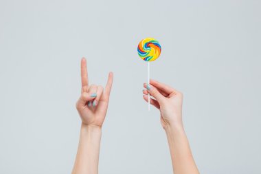 Lolipop tutan ve şeytan işaret gösteren eller