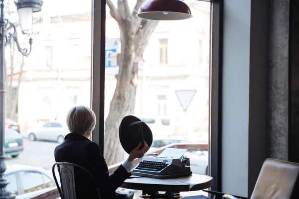 Hübsches blondes Mädchen mit Hut in einem Café — Stockfoto