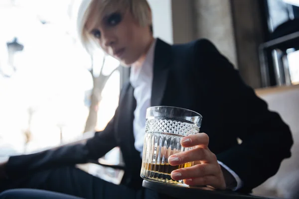 Jonge aantrekkelijke blonde meisje met gefrustreerd look houden van glas — Stockfoto