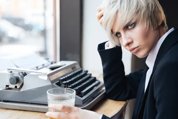 Hermosa joven rubia sentada y bebiendo en la cafetería — Foto de Stock