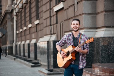 Adam açık havada gitar çalmaya