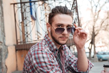 Erkek güneş gözlüğü ve kameraya bakarak kulaklık