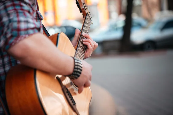 Αρσενικό τα χέρια παίζοντας την κιθάρα του σε εξωτερικούς χώρους — Φωτογραφία Αρχείου