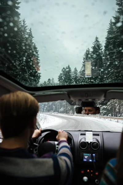 Вид сзади на человека, который едет на машине в снежную погоду — стоковое фото