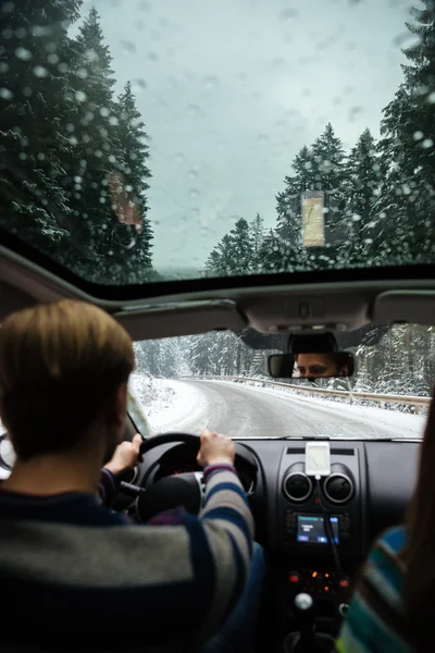 Hombre guapo conduciendo en coche a través del bosque de invierno —  Fotos de Stock