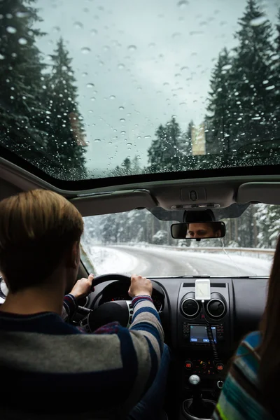 Pareja joven conduciendo en bosque de invierno —  Fotos de Stock