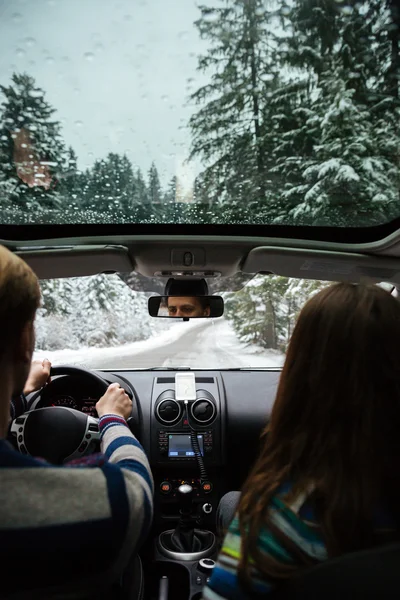 Casal de condução em carro moderno na floresta de inverno — Fotografia de Stock