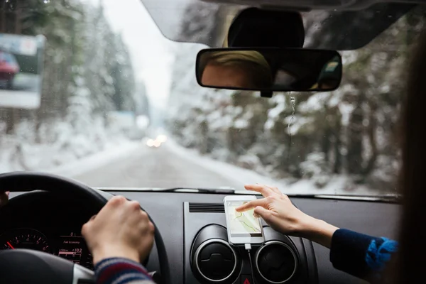 Руки пары вождения и использования навигации на мобильном телефоне — стоковое фото