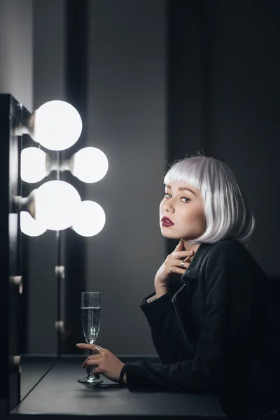 Pensive kvinna med glas champagne tänkande i omklädningsrummet — Stockfoto