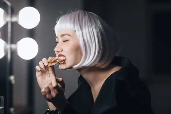 Engraçado mulher loira peruca comer pizza no camarim — Fotografia de Stock