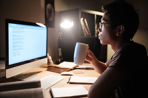 Schöner Mann, der mit Computer lernt und Tee trinkt — Stockfoto