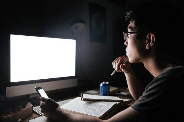 Hombre pensativo que estudia con la computadora de pantalla en blanco y teléfono inteligente — Foto de Stock