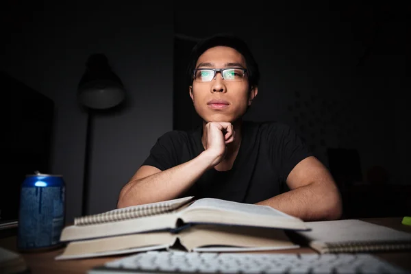 Uomo riflessivo in occhiali che studia usando libri e computer — Foto Stock