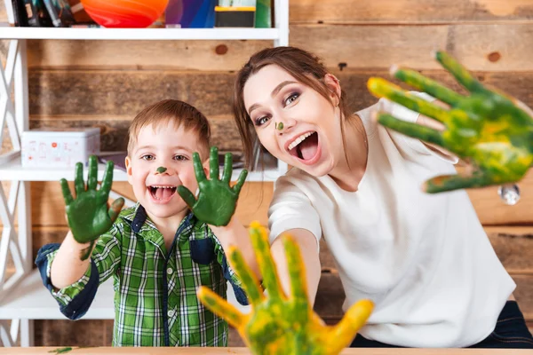 Niño y madre mostrando las manos pintadas con pinturas de colores — Foto de Stock