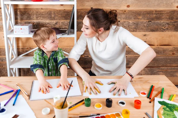 Junge und Mutter drucken bemalte Hände auf Papier — Stockfoto