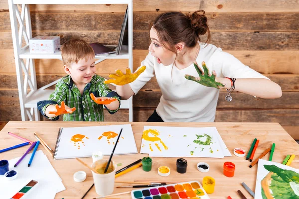 Mutter und Sohn malen Drucke von bemalten Händen auf Papier — Stockfoto