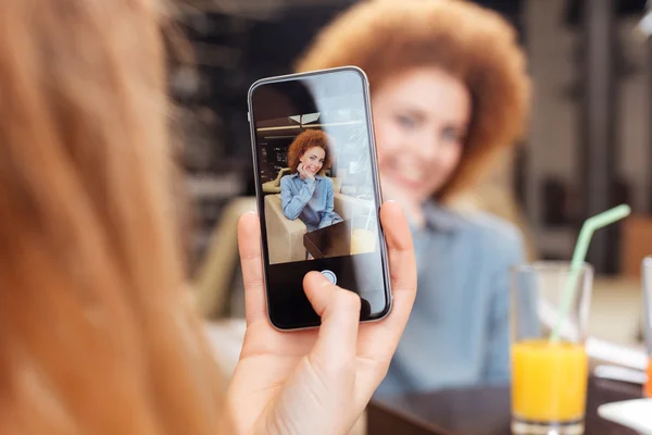 Femmina in possesso di smartphone e scattare foto di donna in caffè — Foto Stock