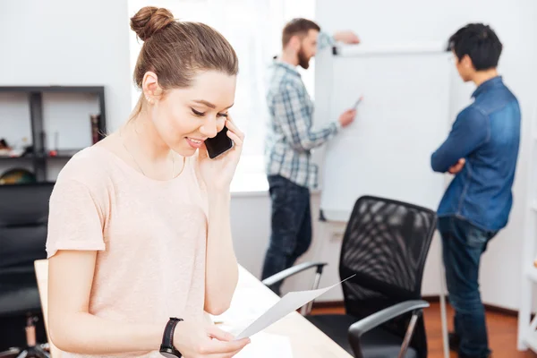 Vrolijke zakenvrouw praten op mobiele telefoon in office — Stockfoto