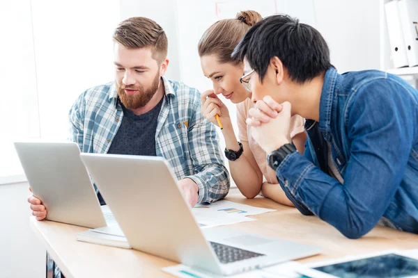 Três empresários trabalhando para o projeto usando laptops no escritório juntos — Fotografia de Stock