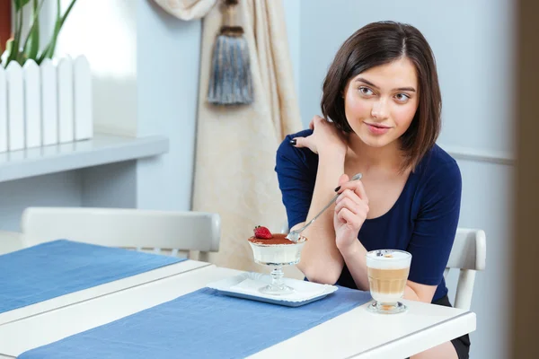 Mulher bonita comendo sobremesa e beber café latte no café — Fotografia de Stock