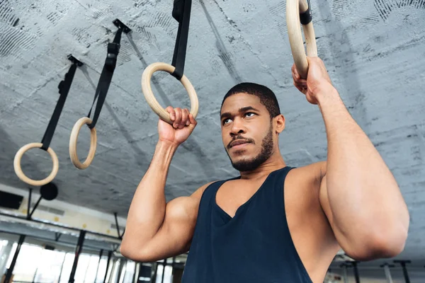 Fitness mężczyzna robi zanurzenie ćwiczenia za pomocą pierścieni — Zdjęcie stockowe