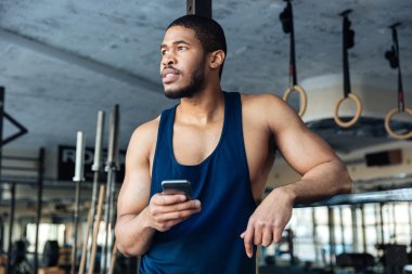 Afro Amerikan vücut geliştirmeci adam holdind smartphone