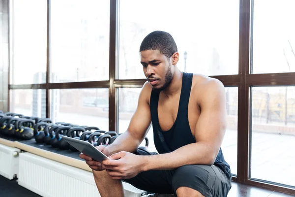 Fitness man with a tablet computer in the gym