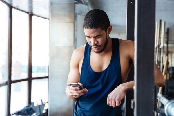 Fitness muži pomocí smartphonu v tělocvičně — Stock fotografie