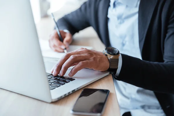 Ritratto ravvicinato di mani di mans multitasking usando il computer portatile — Foto Stock