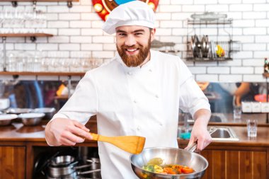 Mutlu çekici Şef yemek pişirme kızartma tavası kullanarak 