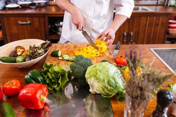 Koch kocht im Stehen Salat in der Küche — Stockfoto