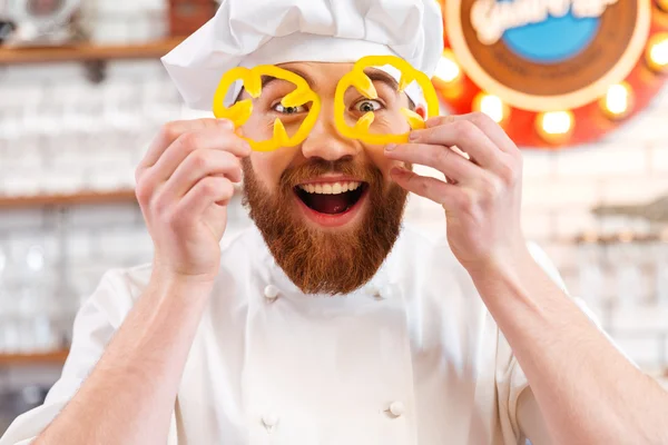Glada holding gul paprika skivor framför ögonen — Stockfoto
