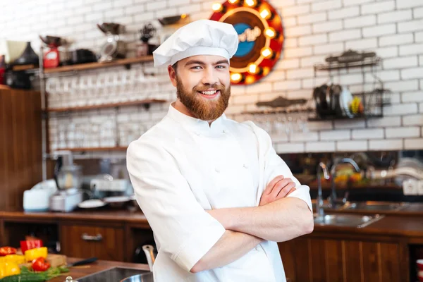 Fröhlicher Koch steht mit verschränkten Armen in der Küche — Stockfoto