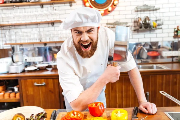 Wütender bärtiger Koch hält Fleischspalter-Messer in der Hand und schreit — Stockfoto