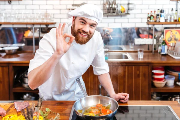 Cozinheiro chef sorrindo preparar comida e mostrando gesto ok — Fotografia de Stock