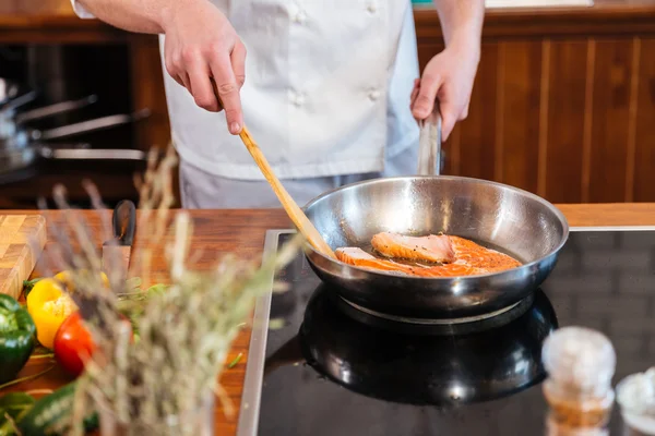 Hands of chef making fresh salmon steak on frying pan — Stock Photo, Image