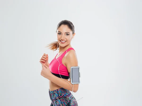 Sorrindo esportes mulher ouvindo música em fones de ouvido — Fotografia de Stock