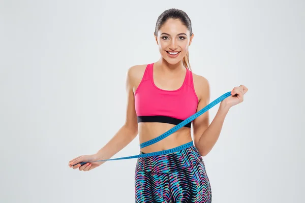 Fitness woman measuring waist with tape — Stock Photo, Image