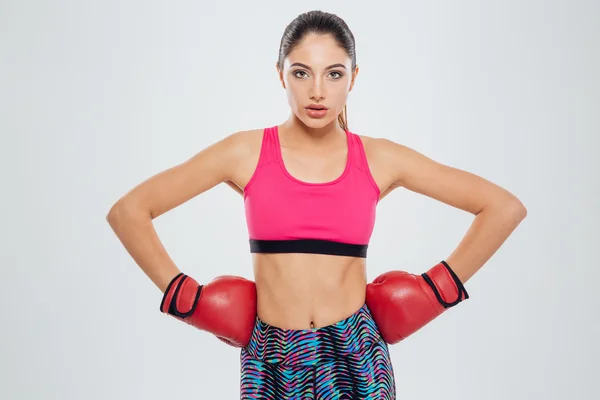 Mujer deportiva seria en guantes de boxeo mirando a la cámara — Foto de Stock