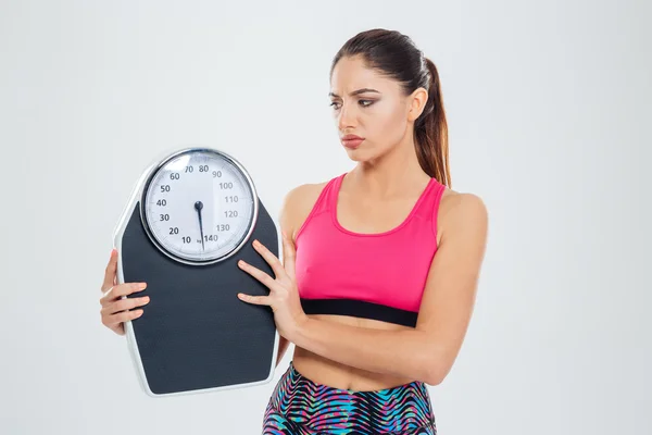 Triste fitness mulher segurando máquina de pesagem — Fotografia de Stock