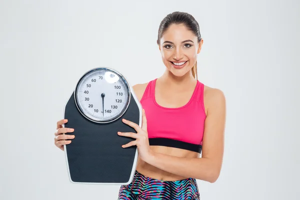 Fitness woman holding weighing machine — Stock Photo, Image