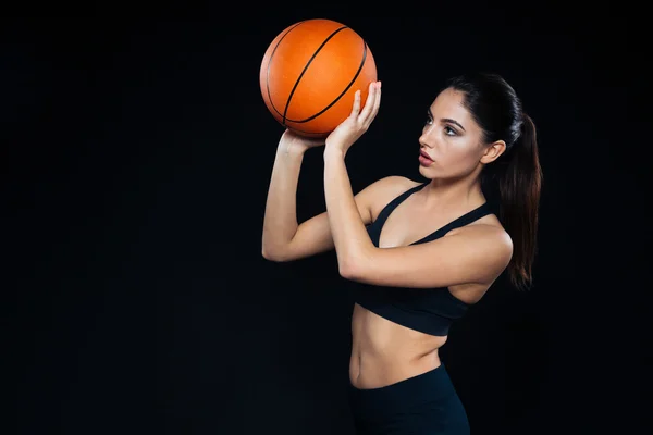 Ayakta ve basketbol topu atma odaklı güzel kadın atlet — Stok fotoğraf
