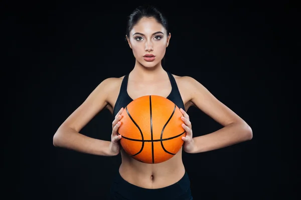 Γυναίκα όμορφη καταλληλότητας κρατώντας και ποζάρει με μπάλα μπάσκετ — Φωτογραφία Αρχείου