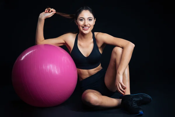 Glücklich süße junge Fitness-Frau sitzt mit lila Fitball — Stockfoto