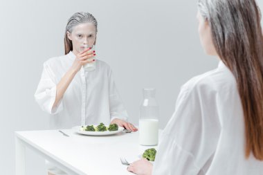 İki kız masada yemek yiyor