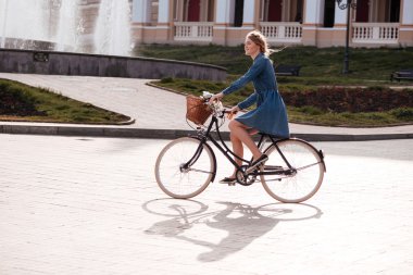 Gülümseyen ve şehrin Bisiklete binmek mutlu kadın