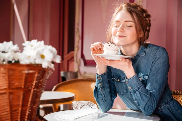 Mujer feliz comiendo dulce sabroso cupcake en la cafetería al aire libre — Foto de Stock