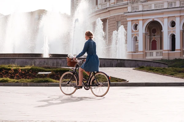 Красивая молодая женщина на велосипеде возле фонтана — стоковое фото
