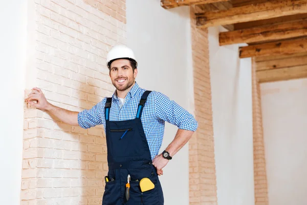 Construtor sorrindo enquanto está em pé dentro de casa — Fotografia de Stock