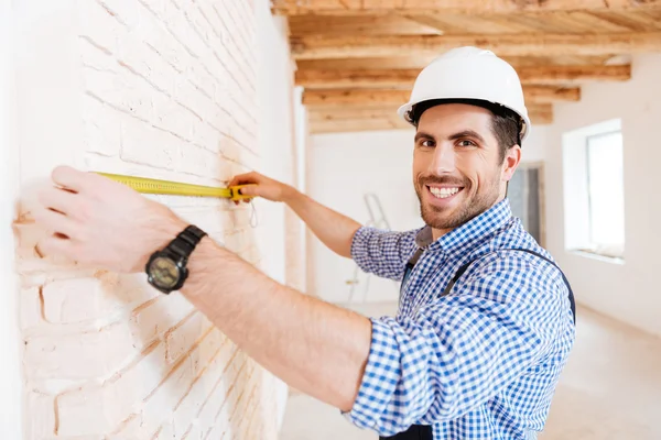 Bauarbeiter mit Maßband in neuem Haus — Stockfoto